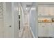 Hallway with kitchen on right side featuring white cabinets and granite countertops at 6520 Pine Meadows Dr, Spring Hill, FL 34606