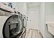 Laundry room features updated washer and dryer with modern grey laminate flooring at 6520 Pine Meadows Dr, Spring Hill, FL 34606