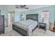 Spacious main bedroom with calming blue walls, ceiling fan, and ensuite bathroom at 6520 Pine Meadows Dr, Spring Hill, FL 34606