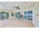 Covered patio with ceiling fan, multiple sliding glass doors and access to the pool area at 6520 Pine Meadows Dr, Spring Hill, FL 34606