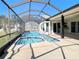 A screened-in pool features a jacuzzi-style add-on and stainless steel handrail at 6520 Pine Meadows Dr, Spring Hill, FL 34606