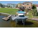 Covered boat on lift at private dock, next to waterfront home at 6528 Louise Ct, Hudson, FL 34667