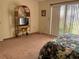 Bedroom with a wicker TV stand and sliding glass doors at 7240 Dogleg Ct, Port Richey, FL 34668