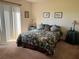 Spacious bedroom with floral bedding and sliding glass doors at 7240 Dogleg Ct, Port Richey, FL 34668