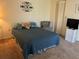 Bedroom with a blue bedspread and an armchair at 7240 Dogleg Ct, Port Richey, FL 34668