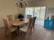Well lit dining room with oval wooden table and blue accent cabinet at 7240 Dogleg Ct, Port Richey, FL 34668