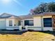 Front view of a single story house with light colored exterior and green accents at 7240 Dogleg Ct, Port Richey, FL 34668
