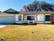 Single-story home with a green door and attached garage at 7240 Dogleg Ct, Port Richey, FL 34668