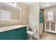 Clean bathroom with teal vanity, decorative shower curtain and tiled flooring at 7464 Acorn Cir, Spring Hill, FL 34606