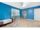 Simple bedroom with a twin-size bed, blue walls, and tile flooring at 7464 Acorn Cir, Spring Hill, FL 34606