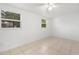 Simple bedroom with tile flooring and two large windows at 7464 Acorn Cir, Spring Hill, FL 34606