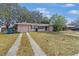 House exterior featuring a two-car driveway and mature trees at 7464 Acorn Cir, Spring Hill, FL 34606
