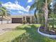 Exterior view of house with a two-car garage and landscaping at 807 Virginia Ave, Tarpon Springs, FL 34689