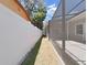 Side yard with a long narrow pathway between fences at 807 Virginia Ave, Tarpon Springs, FL 34689