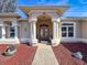 Elegant home entrance with columns and a covered porch at 8284 Cockatoo Rd, Weeki Wachee, FL 34613