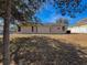 Tan house exterior with a large backyard at 8284 Cockatoo Rd, Weeki Wachee, FL 34613