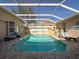 Refreshing screened pool with beach mural and lounge chairs at 8284 Cockatoo Rd, Weeki Wachee, FL 34613