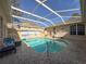 Sparkling screened pool with beach mural and patio furniture at 8284 Cockatoo Rd, Weeki Wachee, FL 34613