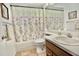 Clean bathroom with floral shower curtain and wood vanity at 9240 Tiara Ct, New Port Richey, FL 34655