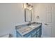 Bathroom with blue vanity, granite countertop, and updated fixtures at 9694 Southern Belle Dr, Weeki Wachee, FL 34613