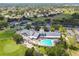 Stunning aerial view of the community center with a pool, tennis courts, and lush green surroundings at 11637 Spindrift Loop, Hudson, FL 34667
