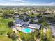 Community aerial view featuring a pool, golf course, tennis courts, and well-maintained landscaping at 11637 Spindrift Loop, Hudson, FL 34667