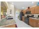 Spacious kitchen featuring stone countertops, wooden cabinetry and stainless steel refrigerator at 11637 Spindrift Loop, Hudson, FL 34667