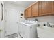 The laundry room boasts a front loading washer and dryer, convenient utility sink and storage cabinets at 11637 Spindrift Loop, Hudson, FL 34667
