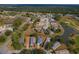 Aerial view of a cozy home in a tranquil golf community with mature trees and water features at 11744 Wheatfield Loop, Hudson, FL 34667