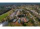 Aerial view of a home nestled in a community surrounded by golf courses and mature trees at 11744 Wheatfield Loop, Hudson, FL 34667