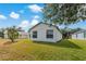A peaceful backyard offering a well-maintained lawn and views of the white home at 11744 Wheatfield Loop, Hudson, FL 34667