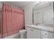 Cozy bathroom featuring a tub with a swan shower curtain, white cabinets, and sink at 11744 Wheatfield Loop, Hudson, FL 34667