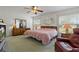 Well-lit bedroom featuring ceiling fan, a decorative mirror, and natural lighting at 11744 Wheatfield Loop, Hudson, FL 34667