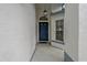 Front entrance with a blue door, hanging light, and decorative tile at 11744 Wheatfield Loop, Hudson, FL 34667