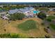 Aerial view of golf course putting green with golfers and the community clubhouse in the background at 11744 Wheatfield Loop, Hudson, FL 34667