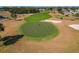 Aerial view of golfers playing on a golf course putting green with sand traps at 11744 Wheatfield Loop, Hudson, FL 34667