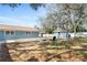 Spacious fenced backyard with mature trees, shed, and fire pit area at 1310 Georgia Ave, Dunedin, FL 34698