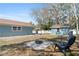 Backyard with a cozy fire pit area, large shade trees, shed, and fencing at 1310 Georgia Ave, Dunedin, FL 34698