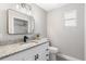 Modern bathroom with granite countertop, a black faucet, updated vanity, and tiled shower with glass doors at 1310 Georgia Ave, Dunedin, FL 34698