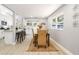 Dining area with a dark wood table, woven chairs, and a view into the modern, bright kitchen at 1310 Georgia Ave, Dunedin, FL 34698