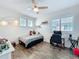 Bright bedroom with wood-look floors, a modern ceiling fan, and a workspace by the window at 14855 Renaissance Ave, Odessa, FL 33556