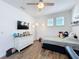 Bright bedroom with wood-look floors, a modern ceiling fan, and a large dresser with shelves at 14855 Renaissance Ave, Odessa, FL 33556