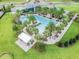 Aerial view of a modern pool with a splash pad, palm trees, lounge chairs, and a covered seating area at 14855 Renaissance Ave, Odessa, FL 33556