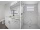 Modern bathroom with white vanity, marble shower with rainfall shower head, and mosaic tile flooring at 15111 Peach Bloom Rd, Brooksville, FL 34614