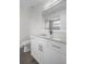 Bathroom features a white vanity, white toilet, modern fixtures, and wood-look flooring at 15111 Peach Bloom Rd, Brooksville, FL 34614