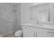 Modern bathroom with white vanity, marble shower with rainfall shower head, and mosaic tile flooring at 15111 Peach Bloom Rd, Brooksville, FL 34614