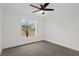 Bedroom showcasing a ceiling fan and a large window with green outdoor views at 15111 Peach Bloom Rd, Brooksville, FL 34614