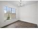 A bright, empty bedroom features wood-look floors and a large window with outdoor views at 15111 Peach Bloom Rd, Brooksville, FL 34614