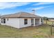 An elevated exterior view showing a large, white home with a covered patio and a well maintained backyard at 15111 Peach Bloom Rd, Brooksville, FL 34614