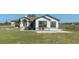 Attractive front exterior with lush landscaping, white stucco, and large picture windows at 15111 Peach Bloom Rd, Brooksville, FL 34614